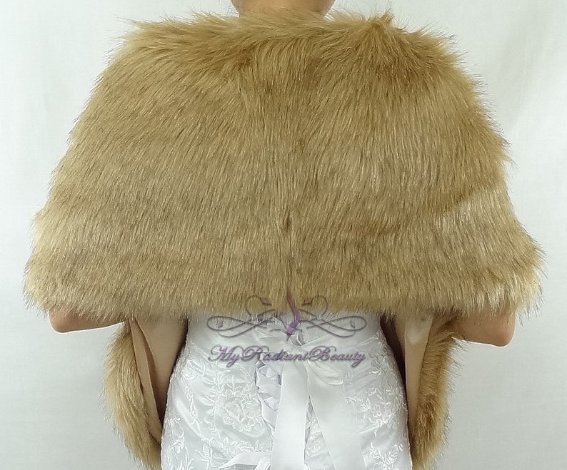 May include: A brown faux fur shawl with a satin lining. The shawl is draped over a white dress with lace detailing.