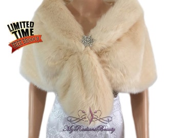 May include: A cream-colored faux fur shawl with a decorative brooch. The shawl is draped over a mannequin wearing a white dress.  Limited Time Free Brooch.