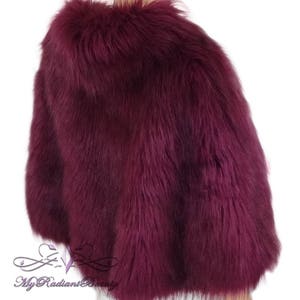 May include: A burgundy faux fur shawl with a soft, fluffy texture.