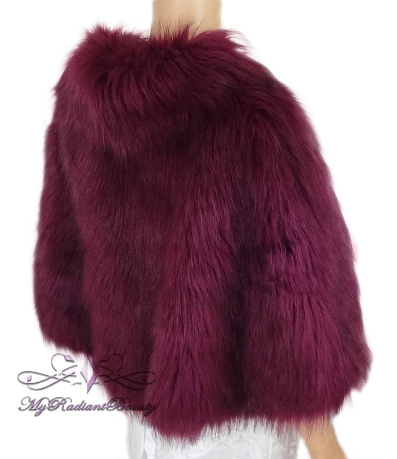 May include: A burgundy faux fur shawl with a soft, fluffy texture.