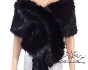 May include: A black faux fur shawl with a soft, fluffy texture. The shawl is draped over a mannequin's shoulders and has a V-neckline.