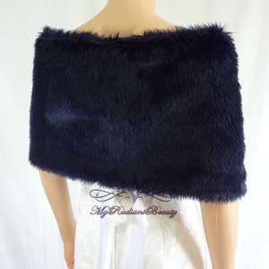 May include: A navy blue faux fur shawl with a soft, fluffy texture. The shawl is draped over a white dress form.