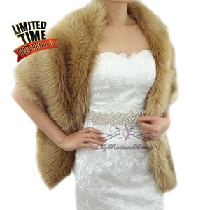 May include: A brown faux fur shawl with a long, flowing design. The shawl is worn over a white strapless dress with a beaded belt. The text "Limited Time Free Brooch" is visible in the top left corner of the image.