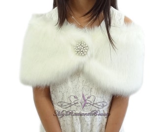 Puede incluir: Chal de piel sintética blanca con un broche adornado con perlas. El chal es suave y esponjoso, y el broche añade un toque de elegancia.