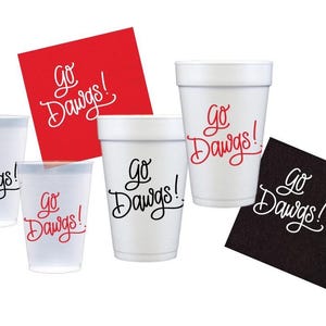 May include: An assortment of white foam cups and napkins with the text "Go Dawgs!" in red and black script. The image includes cups of various sizes and red and black napkins.
