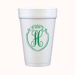 May include: White foam cup with a green monogram of the letter H inside a shield shape.