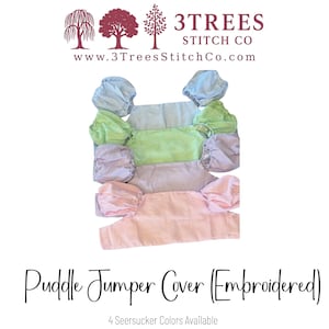 May include: A stack of four seersucker Puddle Jumper Covers in pastel colors: blue, green, lavender, and pink. Each cover has matching ruffled sleeves. The image includes the text "Puddle Jumper Cover (Embroidered)" and "4 Seersucker Colors Available."
