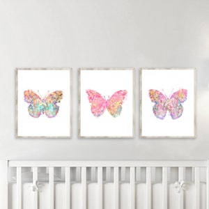 May include: Three framed prints of watercolor butterflies with pink, purple, and blue hues. The butterflies are set against a white background.