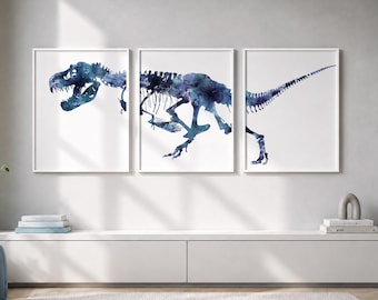 May include: A triptych of three framed wall art prints featuring a blue watercolor illustration of a Tyrannosaurus Rex skeleton. The dinosaur skeleton is divided across three separate white frames, showing the head, torso, and tail.