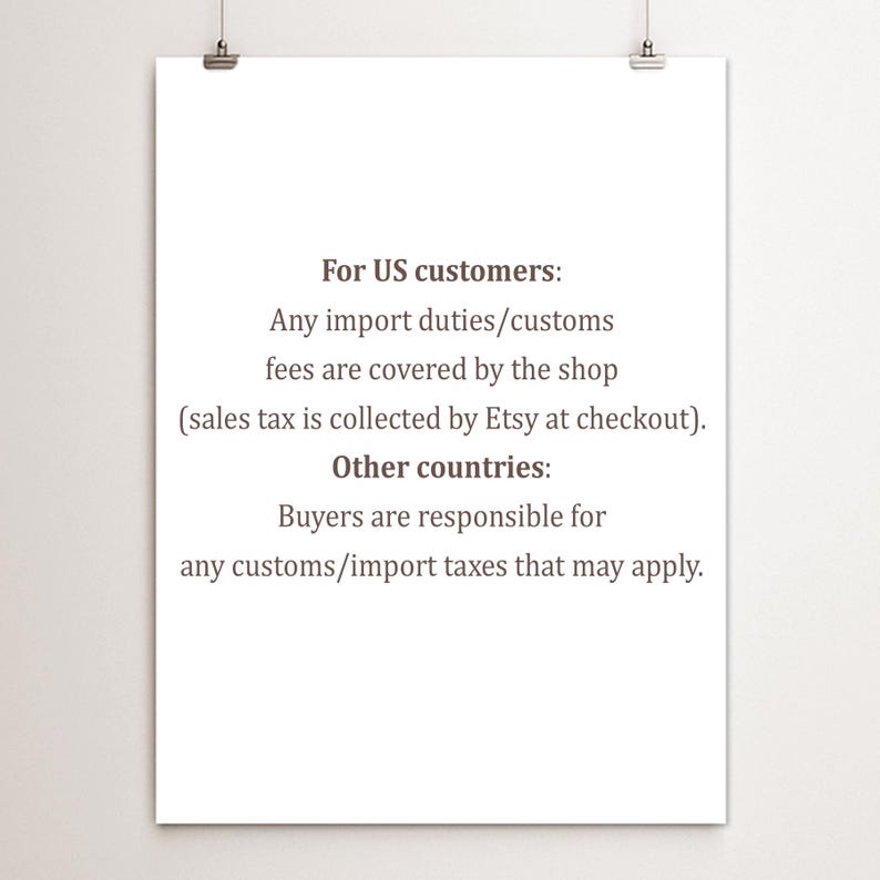 May include: A white poster with black text detailing import duty and customs fees for US and international customers. The poster is held by two silver clips.