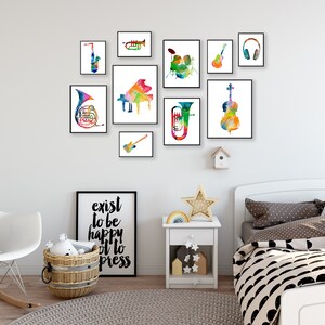 K&ouml;nnte beinhalten: Eine wei&szlig;e Wand mit einer Sammlung gerahmter Aquarellbilder von Musikinstrumenten. Die Instrumente umfassen ein Saxophon, eine Trompete, ein Klavier, eine Tuba, ein Cello, eine Gitarre und ein Schlagzeug. Die Bilder sind in einem Raster angeordnet. Der Text "exist to be happy not to impress" ist auf einem schwarz-wei&szlig;en gerahmten Poster gedruckt.