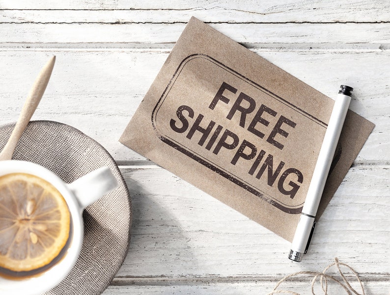 K&ouml;nnte beinhalten: Ein brauner Papierumschlag mit dem Stempel "FREE SHIPPING" in schwarzer Tinte. Ein wei&szlig;er Stift liegt auf dem Umschlag.