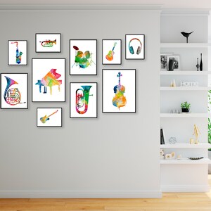 K&ouml;nnte beinhalten: Ein Set aus neun bunten Aquarelldrucken mit Musikinstrumenten, darunter ein Saxophon, eine Trompete, ein Schlagzeug, eine Gitarre, Kopfh&ouml;rer, ein Cello, eine Posaune, ein Bass und ein Fl&uuml;gel. Die Drucke sind in einem Raster an einer wei&szlig;en Wand angeordnet.