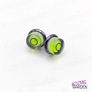 Two black and silver level bubble earrings with a green bubble level inside.