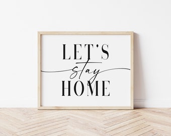 Może przedstawiać: Wydruk w ramie z tekstem "LET'S stay HOME" czarnymi literami na białym tle.