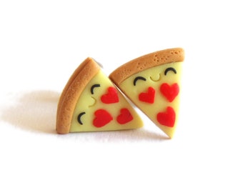May include: A pair of earrings shaped like pizza slices with red heart-shaped pepperoni and smiling faces.
