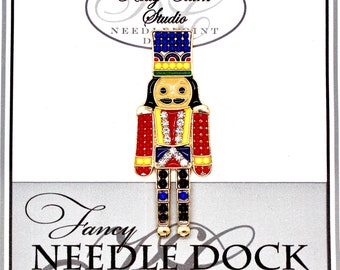 Nutcracker Needle Minder: emaliowany dok na igły z kryształkami Swarovskiego w kolorze czerwonym i niebieskim