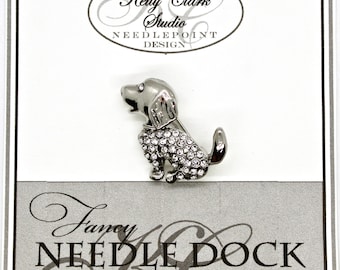 Puede incluir: Un broche de perro plateado con un diseño de pedrería. El broche está en una tarjeta blanca con el texto "Kelly Clark Studio Needlepoint Design" y "Fancy Needle Dock Studio".