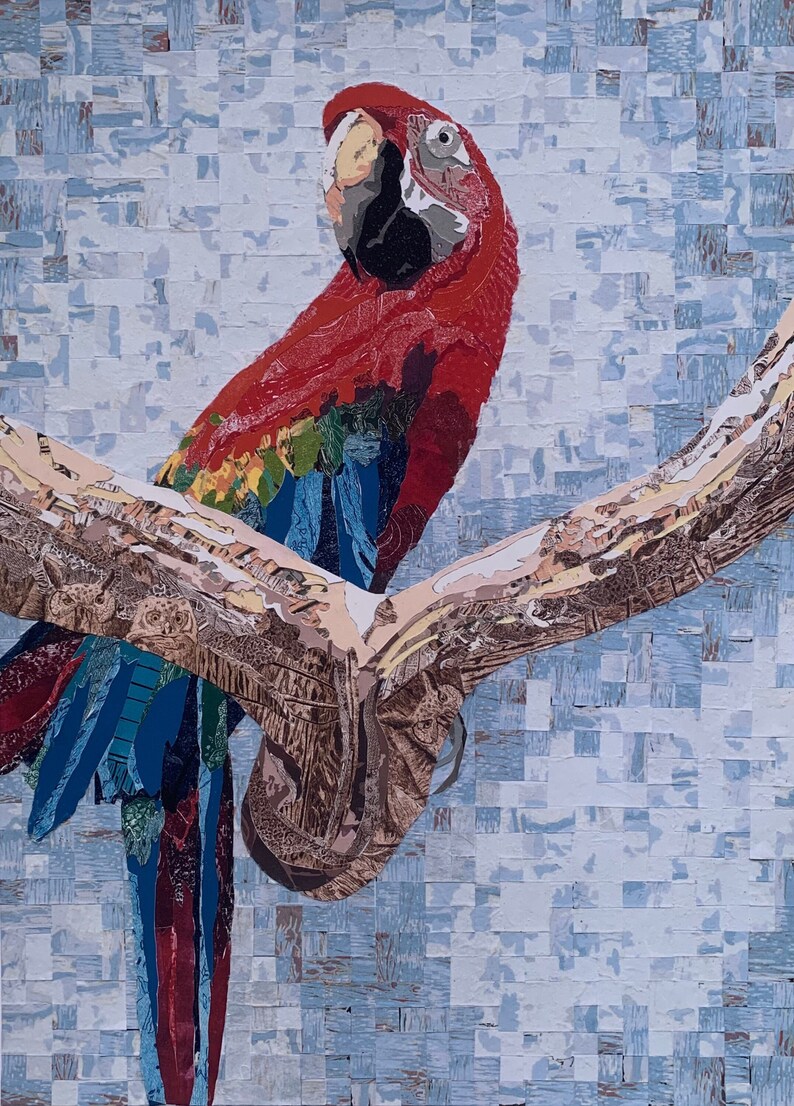 Pu&ograve; includere: Un collage colorato di un'ara scarlatta posata su un ramo. L'uccello presenta piume vibranti rosse, blu, gialle e verdi. Il ramo &egrave; un mix di tonalit&agrave; marroni e beige, su uno sfondo azzurro chiaro strutturato.