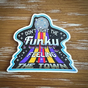 May include: A black and blue sticker with a disco ball and the text "Don't fight the Funky Feeling the Town".