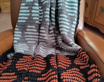 Crocheted Mosaic afghan in black, white, light blue, light yellow, rust and grey.