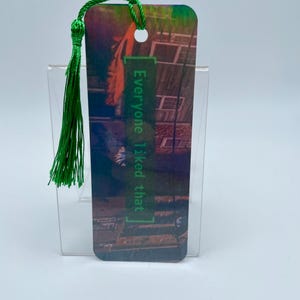 May include: A green bookmark with a tassel. The bookmark has a colorful image of a building with the text "everyone liked that" in green.