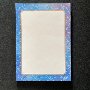 May include: A blank notepad with a blue and purple geometric pattern border. The border has a gold frame.