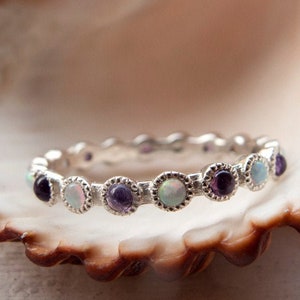 Anillo de eternidad único elaborado en oro o plata engastado con piedras preciosas alternas, amatistas y ópalos blancos, en un engaste milgrain de estilo vintage.
