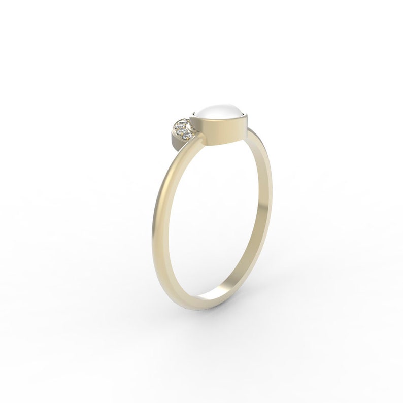 May include: A gold ring with a white oval gemstone and smaller diamonds set on the band.