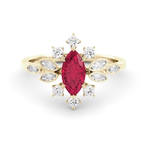 Può includere: Un anello d'oro con un rubino centrale a taglio marquise, circondato da diamanti bianchi e dettagli a forma di foglie. L'anello ha un design delicato e floreale, perfetto per un'occasione speciale.