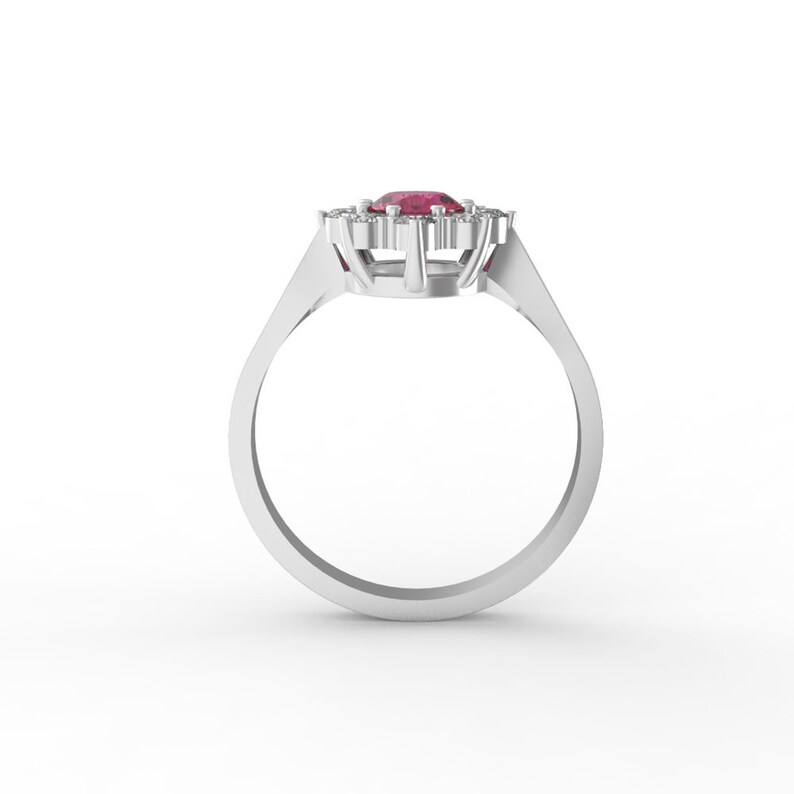 May include: A silver ring with a large red gemstone surrounded by smaller white gemstones.