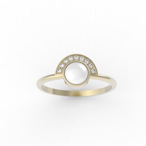 May include: A gold ring with a white pearl set in a half-circle of small diamonds.