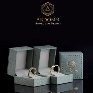 May include: Three green ring boxes with gold trim and the logo "ARDONN SOURCE OF BEAUTY" on the front. Two boxes have gold rings inside.
