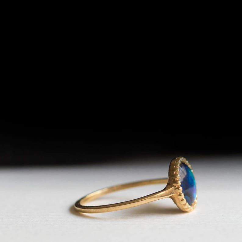May include: A gold ring with a blue and green abalone shell set in a scalloped bezel.