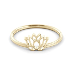 May include: A gold-toned ring with a delicate lotus flower design. The ring is simple and elegant, perfect for everyday wear.