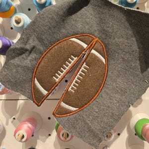 May include: A gray fabric patch with an embroidered brown and white football design.