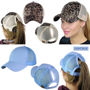 May include: Two views of a light blue and a leopard print baseball cap with a mesh back and a ponytail hole. The caps are shown on a white background.