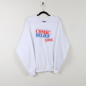 May include: White long-sleeve sweatshirt with a red and blue graphic print that says "Comic Relief 2006".