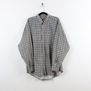 May include: A long-sleeved button-down shirt with a white background and a blue and yellow geometric pattern.