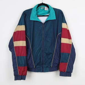 May include: A blue, teal, red, and beige windbreaker jacket with a zipper closure. The jacket has a mesh fabric and a contrasting color design on the sleeves.