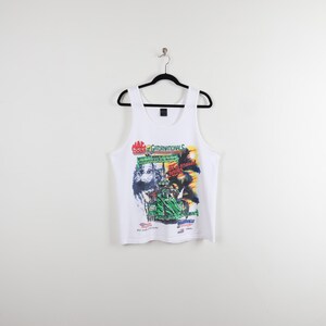 May include: White tank top with a colorful graphic print featuring the text "Gatornationals" and a race car design. The sleeveless shirt is hanging on a black hanger against a white background.