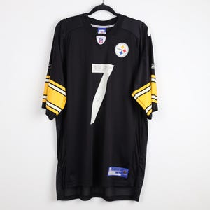 May include: A black Pittsburgh Steelers football jersey featuring the number 7 in white on the front, a team logo on the upper left chest, an NFL shield at the neckline, and yellow and white stripes on the short sleeves with Reebok branding.