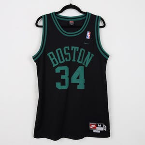 May include: Black basketball jersey with green trim and the words "Boston" and "34" on the front. The jersey has a Nike logo on the right shoulder and a Nike tag on the bottom right.