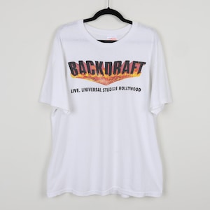 May include: White t-shirt with a graphic print of the words "BACKDRAFT" in black with flames behind the text. The text "LIVE. UNIVERSAL STUDIOS HOLLYWOOD" is printed below the graphic.