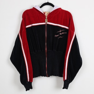 May include: A red and black zip-up hoodie with white accents. The hoodie features a drawstring hood, a cinched waist, and the words "Apple Bottoms" embroidered on the front. The sleeves have a red stripe with a white accent.