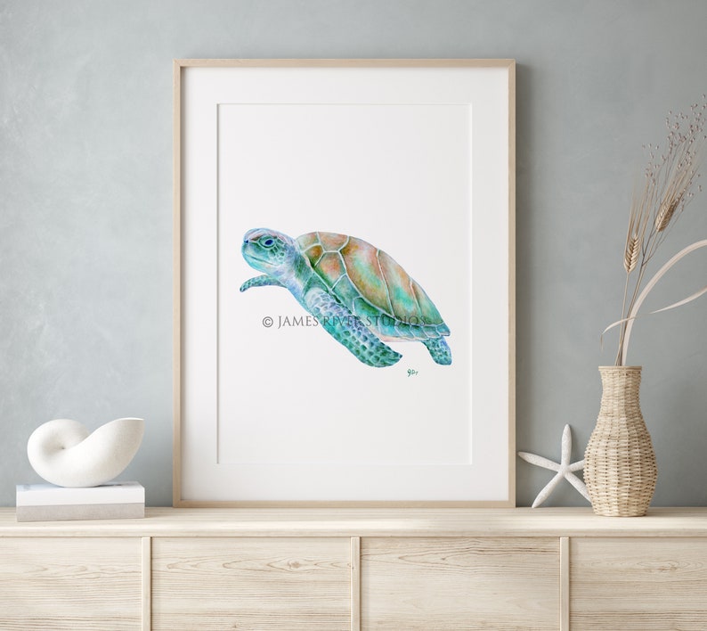 May include: A watercolor painting of a sea turtle swimming in the ocean. The turtle is painted in shades of blue, green, and brown. The painting is framed in a simple wooden frame.