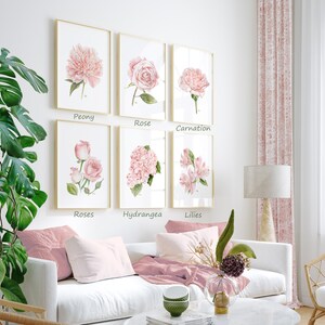 May include: Six framed watercolor paintings of pink flowers, each with a different flower type and the name of the flower printed below the image. The flowers are peony, rose, carnation, roses, hydrangea, and lilies.