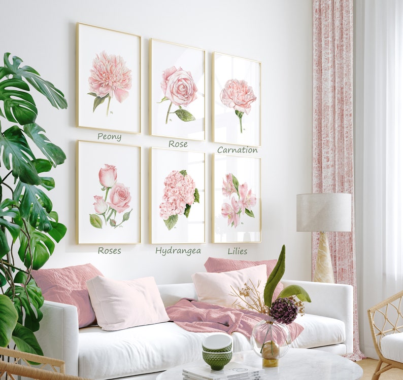 May include: Six framed watercolor paintings of pink flowers, each with a different flower type and the name of the flower printed below the image. The flowers are peony, rose, carnation, roses, hydrangea, and lilies.
