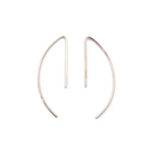 May include: A pair of silver-toned, minimalist earrings. Each earring features a curved, crescent-shaped design with a straight post extending from the top. The earrings are displayed against a plain white background, highlighting their sleek, modern aesthetic.