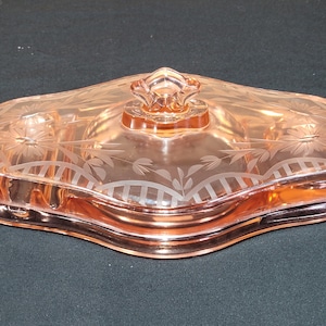 Excepcional tocador vintage de cristal rosa Cambridge con tapa grabada. Tarro de maquillaje con tapa.
